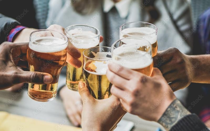 a group of hands holding glasses of beer